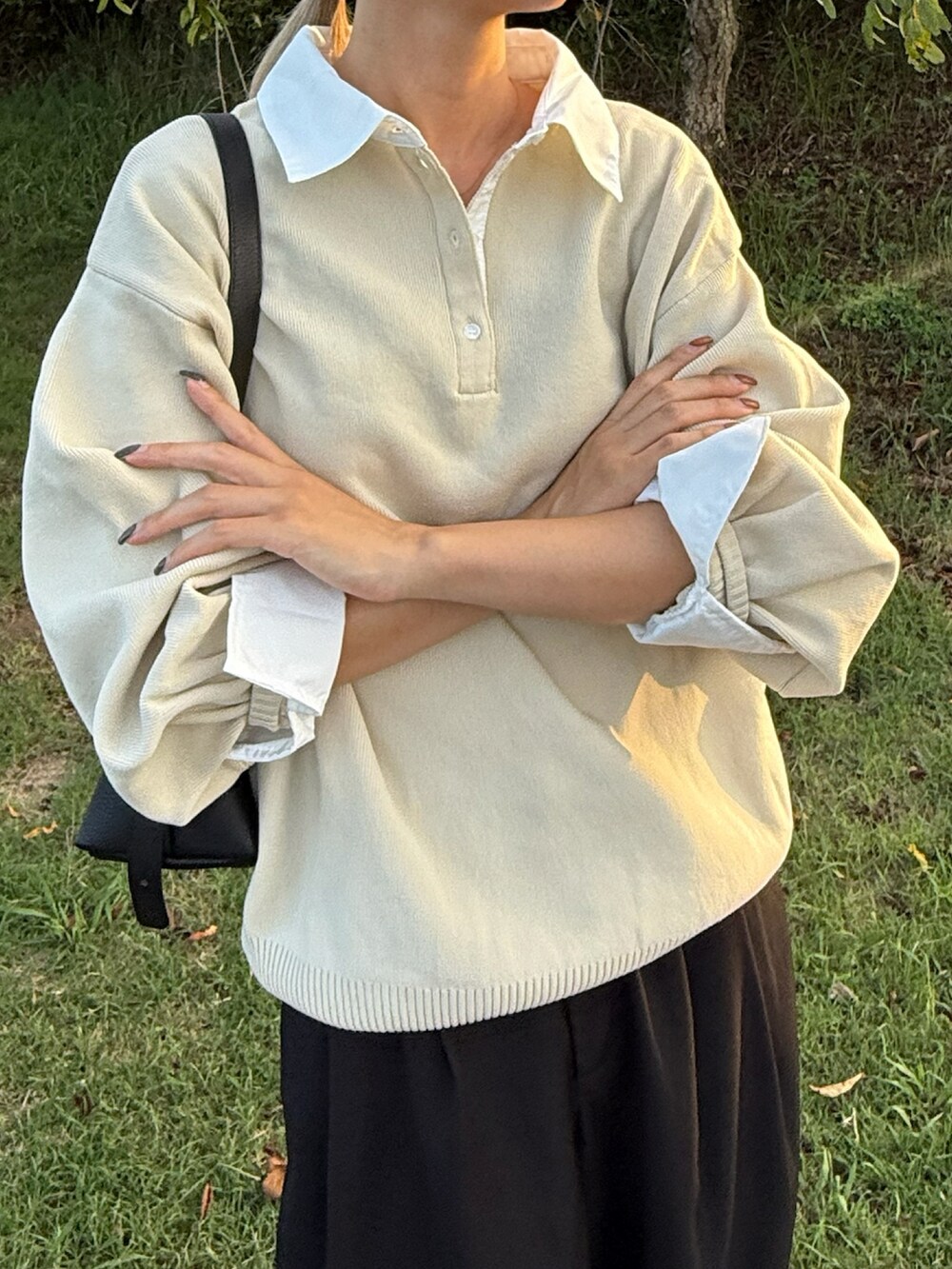 ブラック系のスラックス、ホワイト系のニット/セーターを着用したレディースの秋コーディネートの2枚目の写真