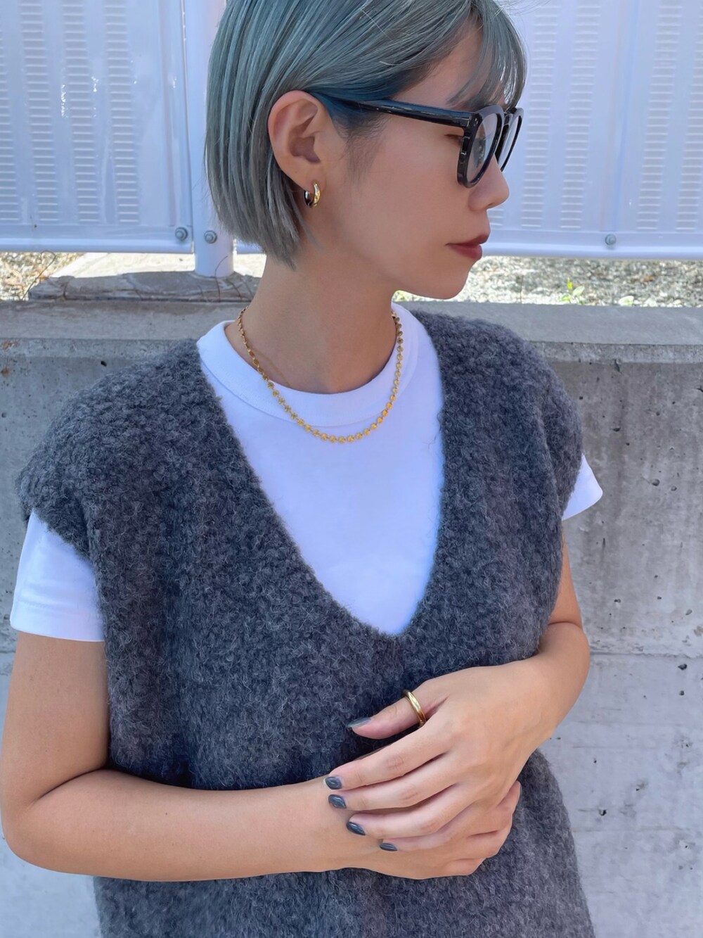 ブラック系のスニーカー、グレー系のベスト、グレー系のパンツを着用したレディースの秋コーディネートの4枚目の写真