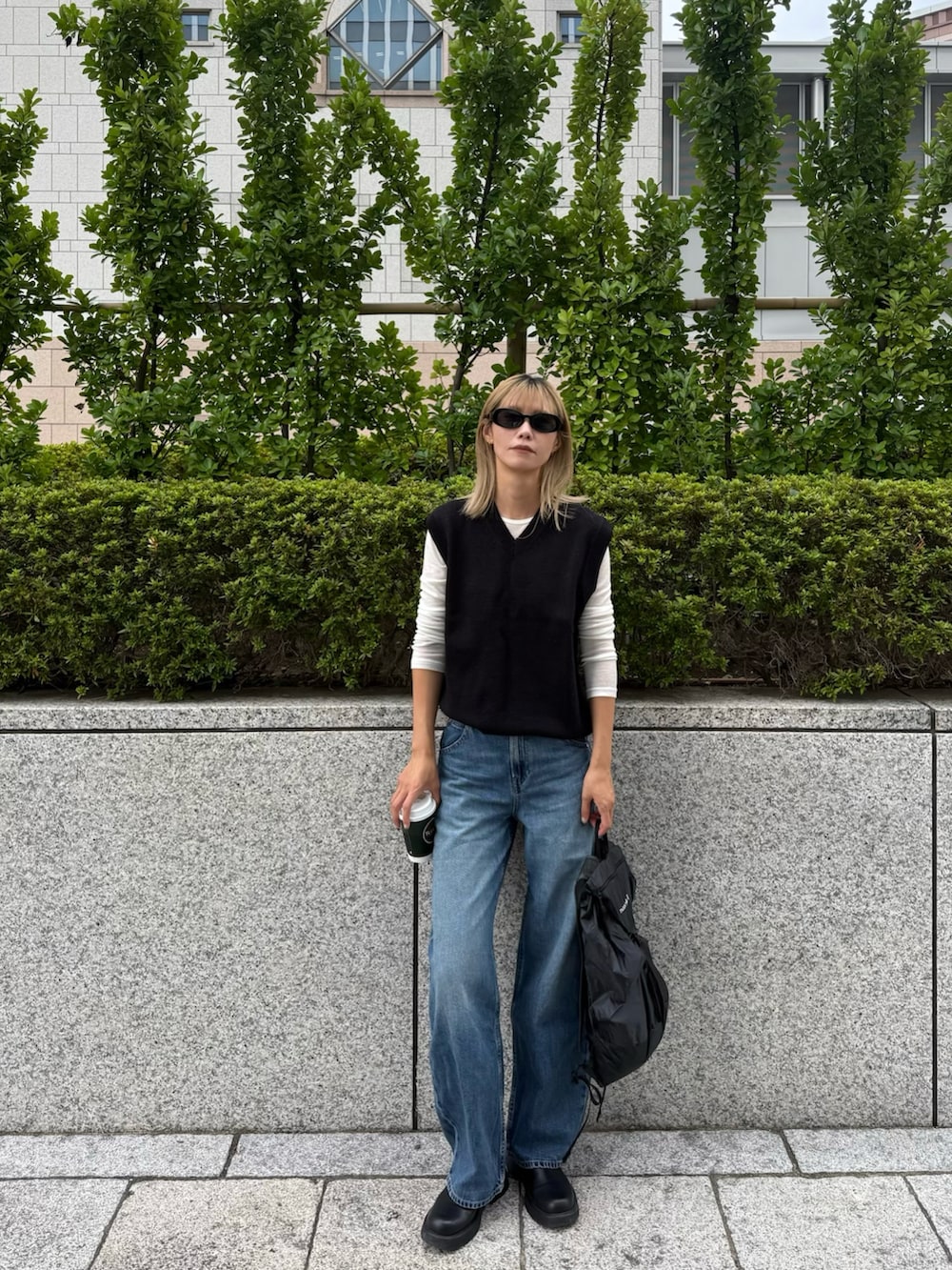 ブラック系のトップス、ブラック系のバッグを着用したレディースの秋コーディネートの2枚目の写真