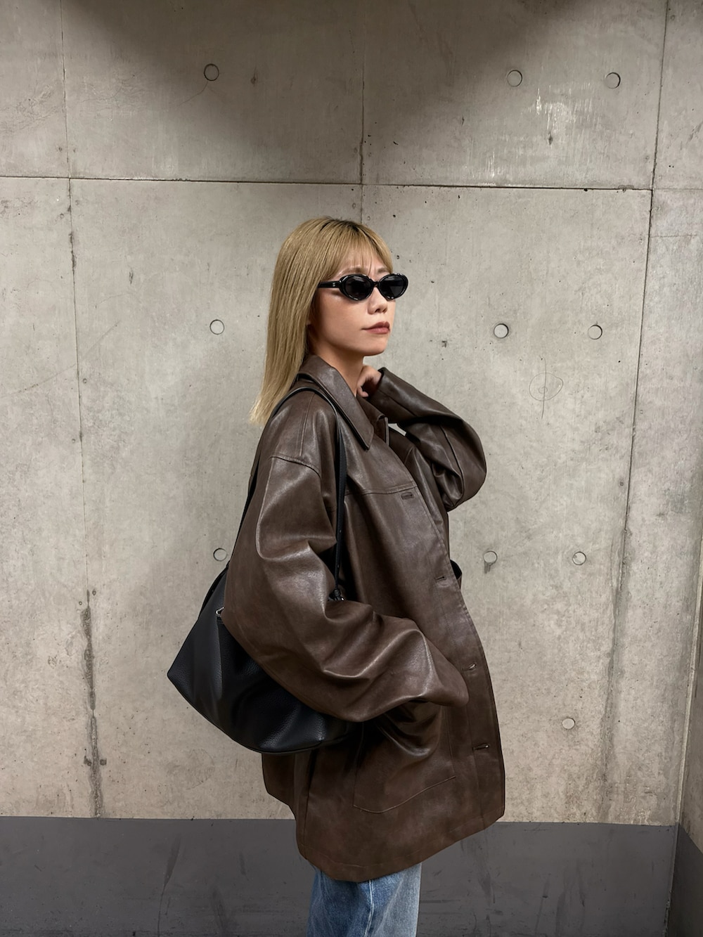 ブラウン系のステンカラーコート、ブラック系のサンダルを着用したレディースの秋コーディネートの3枚目の写真