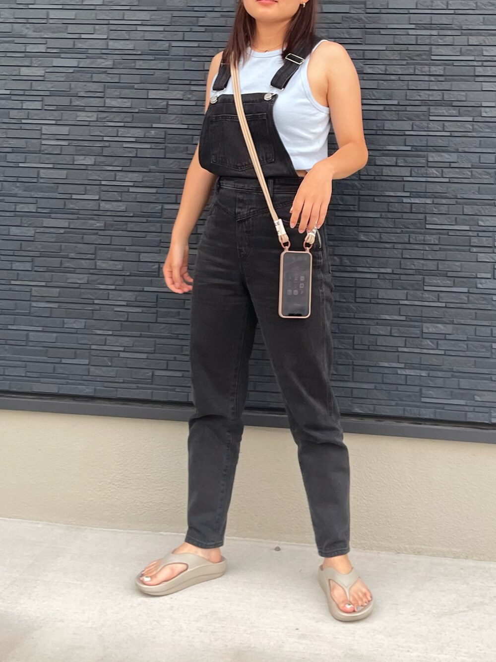 ブラック系のサロペット/オーバーオール、ブルー系のタンクトップ、ベージュ系のサンダルを着用したレディースの秋コーディネートの2枚目の写真