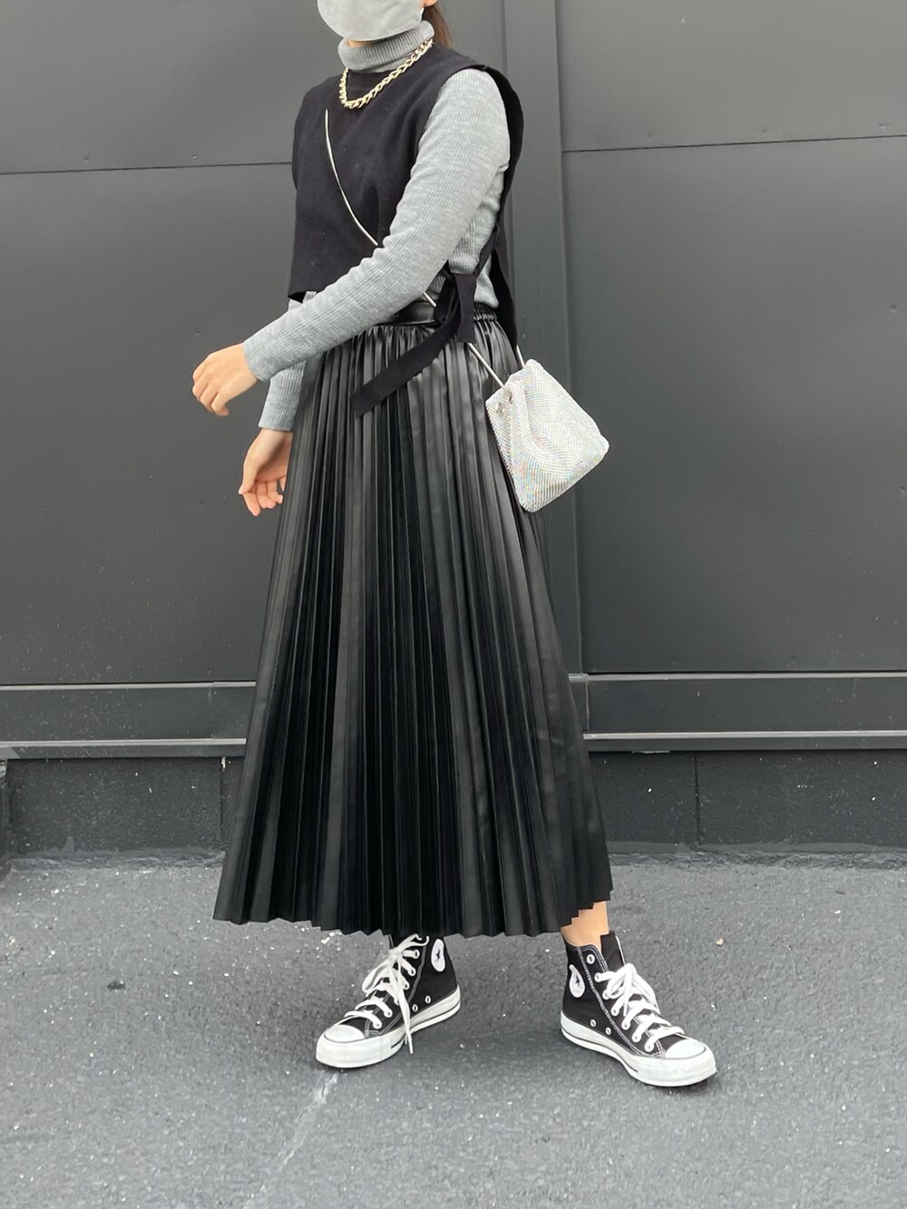 ブラック系のスカート、ブラック系のスニーカー、ブラック系のベストを着用したレディースの冬コーディネートの2枚目の写真