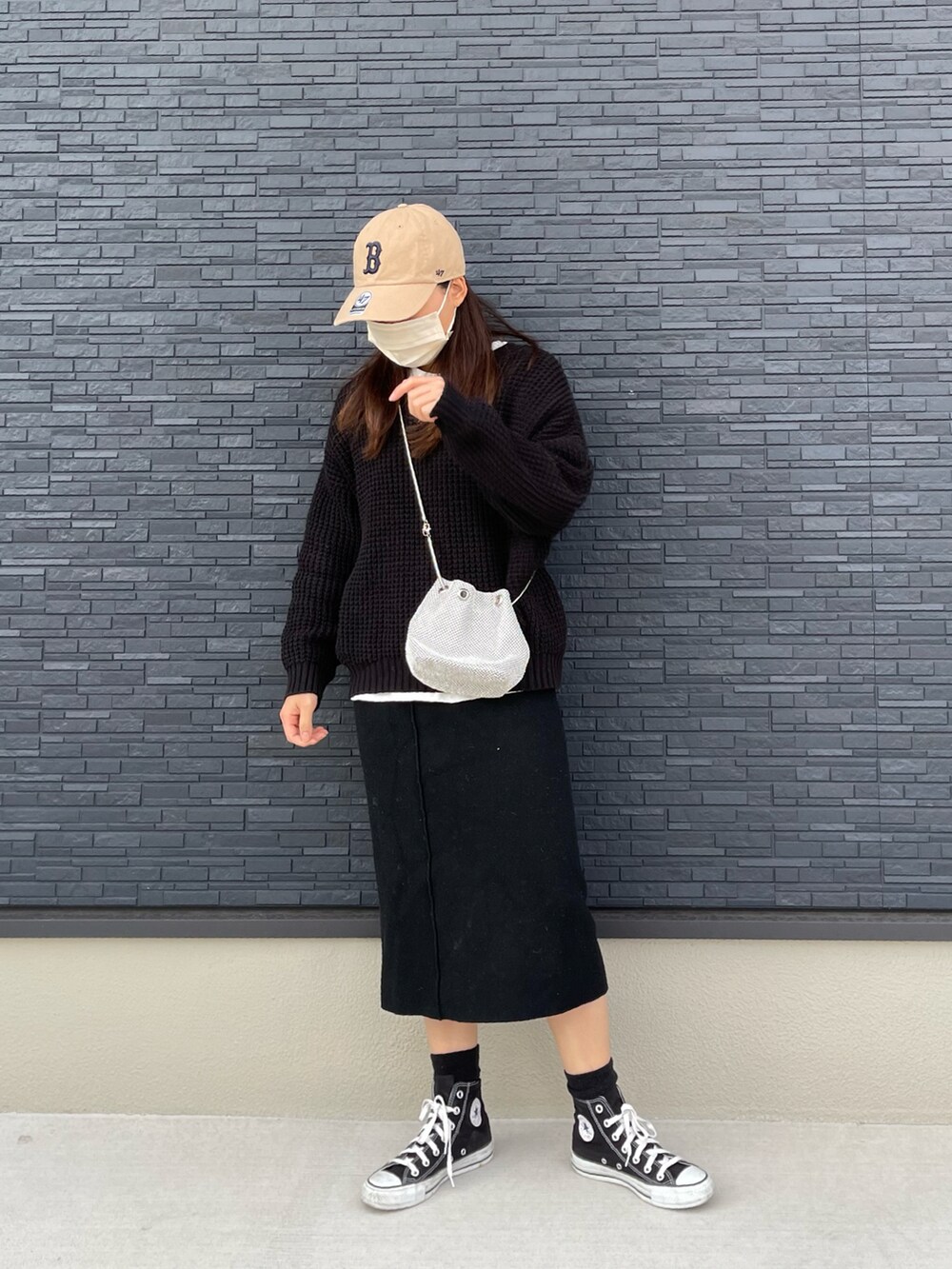 ブラック系のニット/セーター、ブラック系のスカート、ブラック系のスニーカーを着用したレディースの冬コーディネートの2枚目の写真