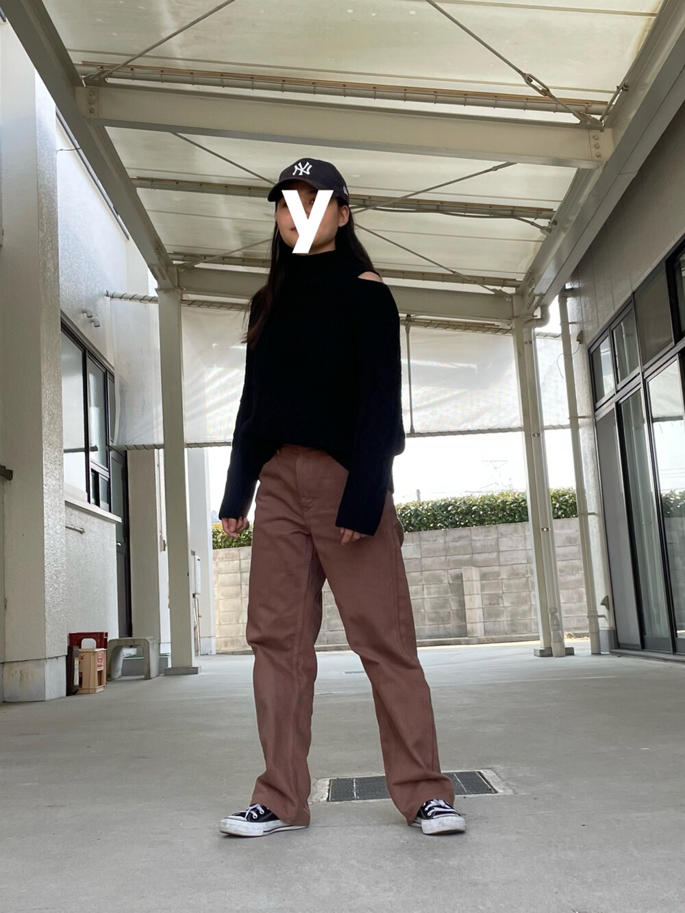 ブラウン系のパンツ、ブラック系のスニーカー、ブラック系のニット/セーターを着用したレディースの春コーディネートの2枚目の写真