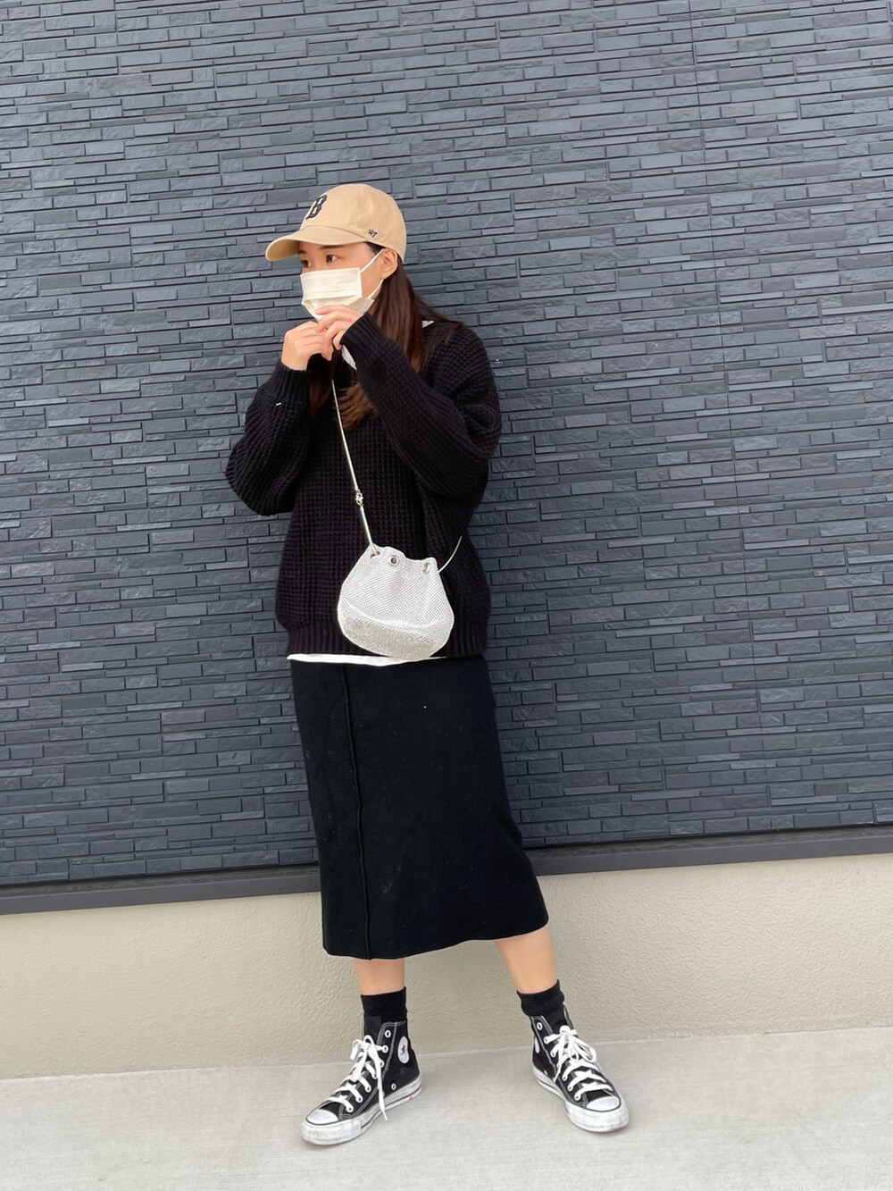 ブラック系のニット/セーター、ブラック系のスカート、ブラック系のスニーカーを着用したレディースの冬コーディネートの3枚目の写真