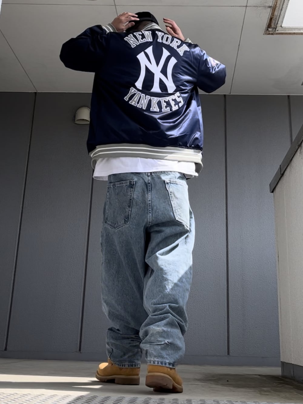 ブルー系のスタジャン、イエロー系のブーツ、ホワイト系のTシャツ/カットソーを着用したメンズの春コーディネートの3枚目の写真