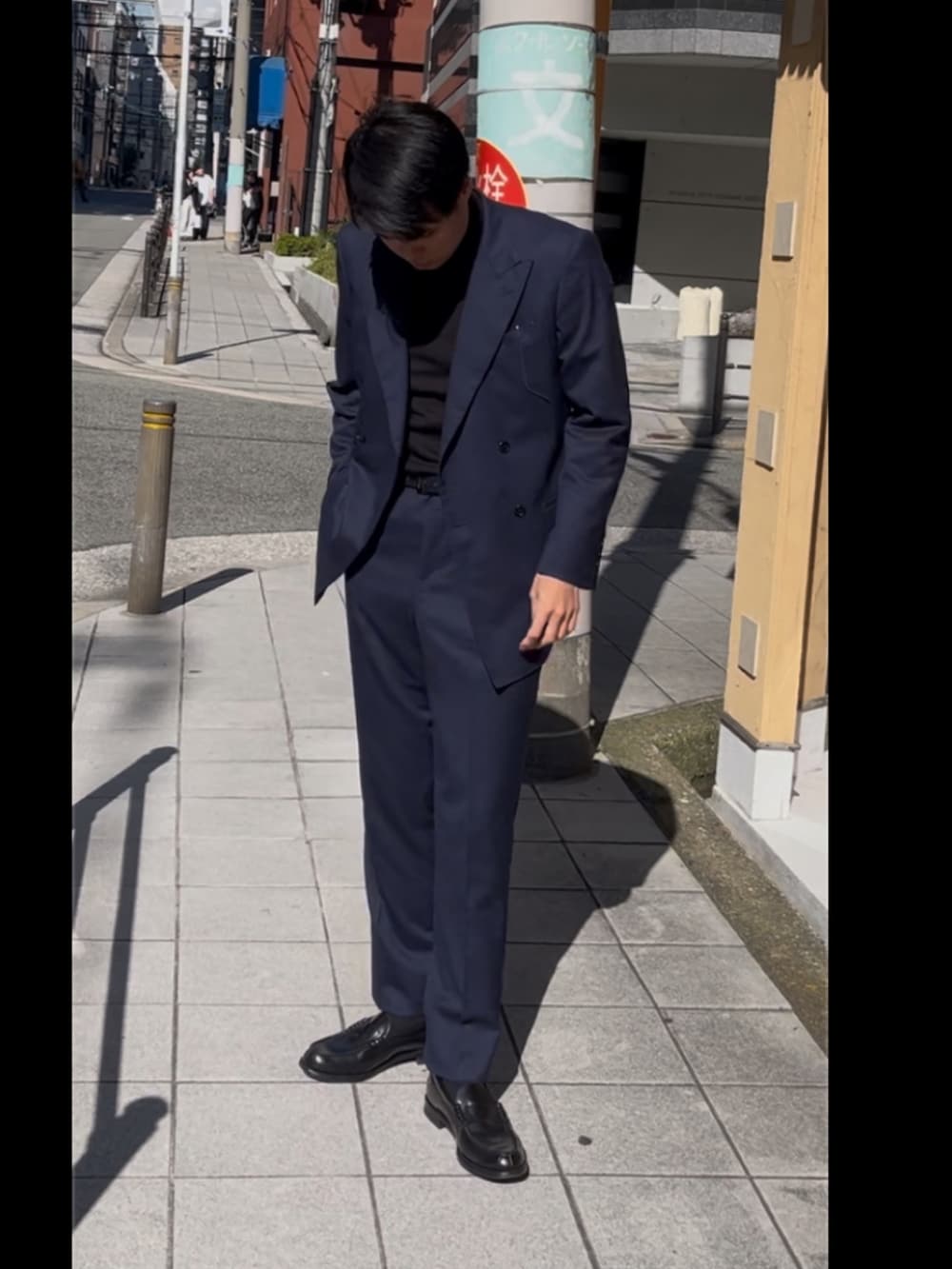 ブルー系のテーラードジャケット、ブラック系のローファーを着用したメンズの秋コーディネートの3枚目の写真