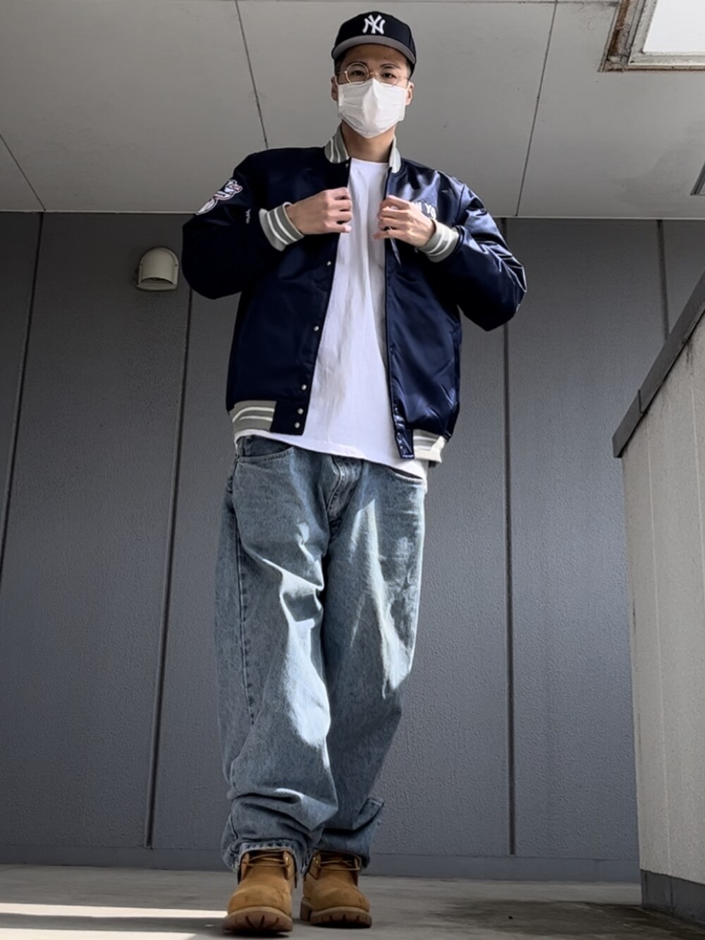 ブルー系のスタジャン、イエロー系のブーツ、ホワイト系のTシャツ/カットソーを着用したメンズの春コーディネートの2枚目の写真