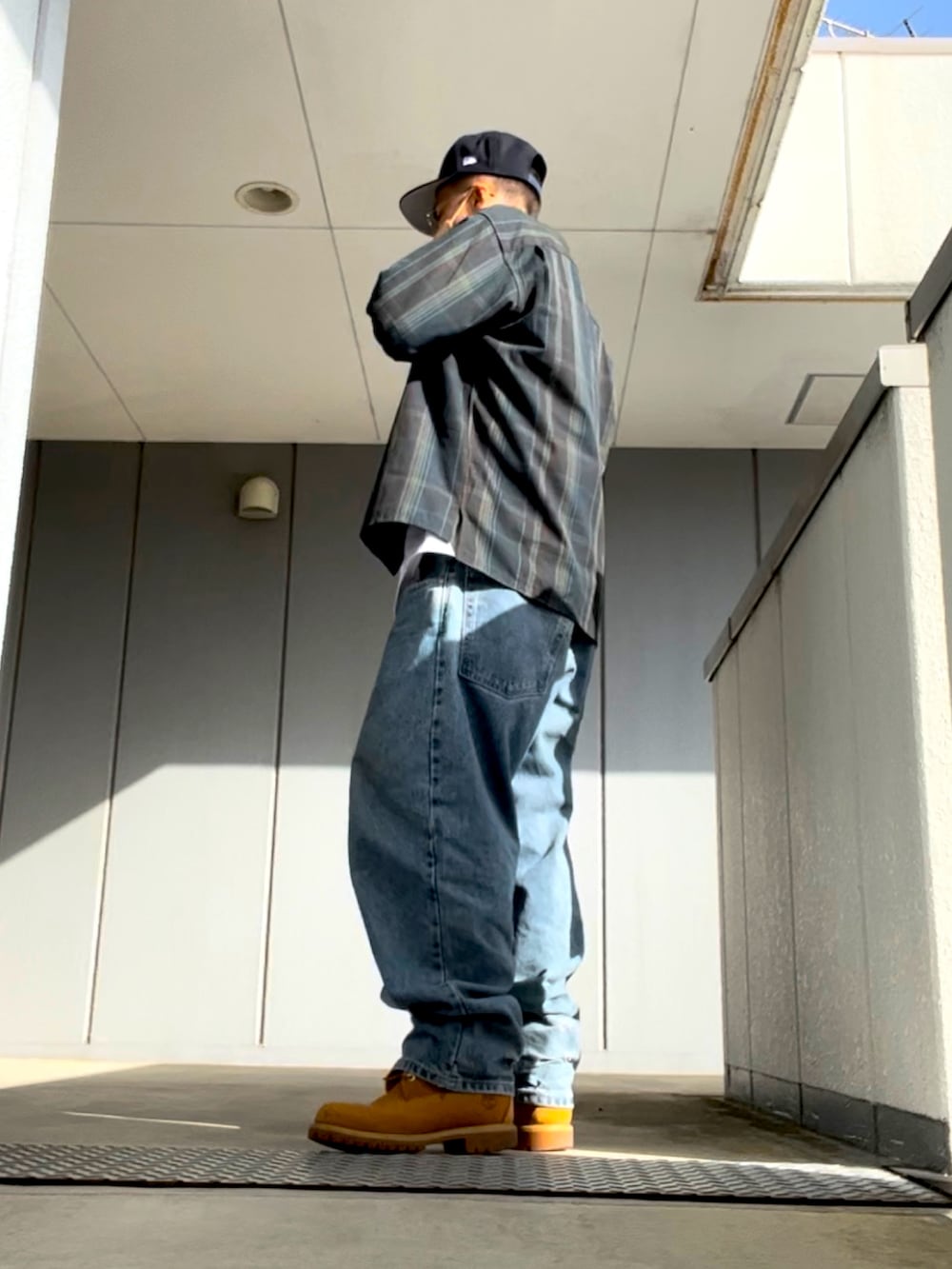 ブルー系のデニムパンツ、イエロー系のブーツ、ホワイト系のTシャツ/カットソーを着用したメンズの春コーディネートの2枚目の写真