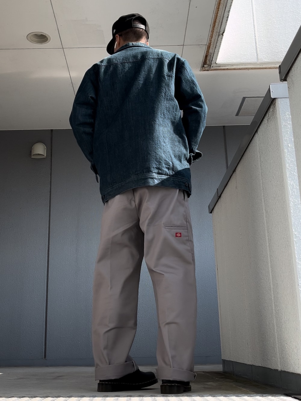 シルバー系のチノパンツ、ブラック系のブーツ、ブルー系のデニムジャケットを着用したメンズの秋コーディネートの5枚目の写真