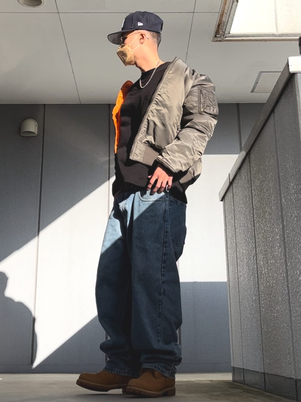 ブルー系のデニムパンツ、ブラック系のTシャツ/カットソー、イエロー系のブーツを着用したメンズの春コーディネートの2枚目の写真