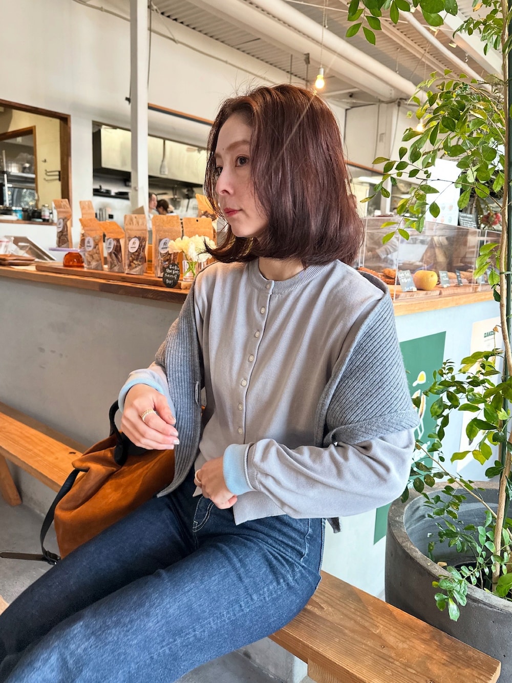 グレー系のカーディガン/ボレロ、イエロー系のショルダーバッグを着用したレディースの冬コーディネートの2枚目の写真