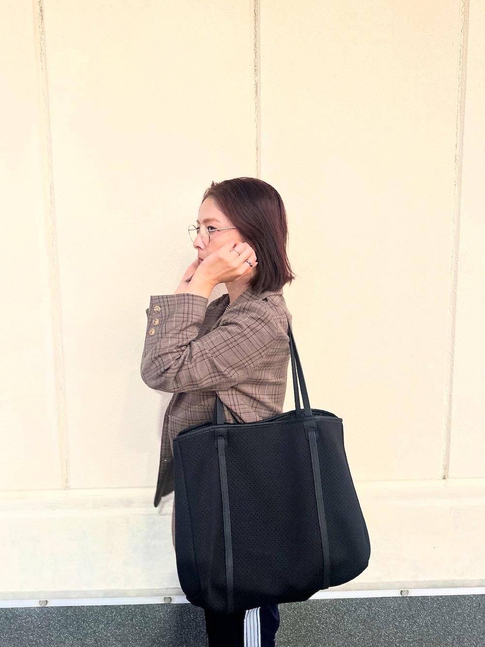 ブラック系のトートバッグを着用したレディースの秋コーディネートの4枚目の写真