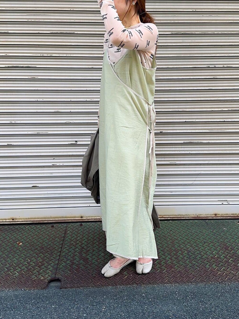 グリーン系のワンピース/ドレス、ホワイト系のパンプス、ベージュ系のTシャツ/カットソーを着用したレディースの春コーディネートの2枚目の写真