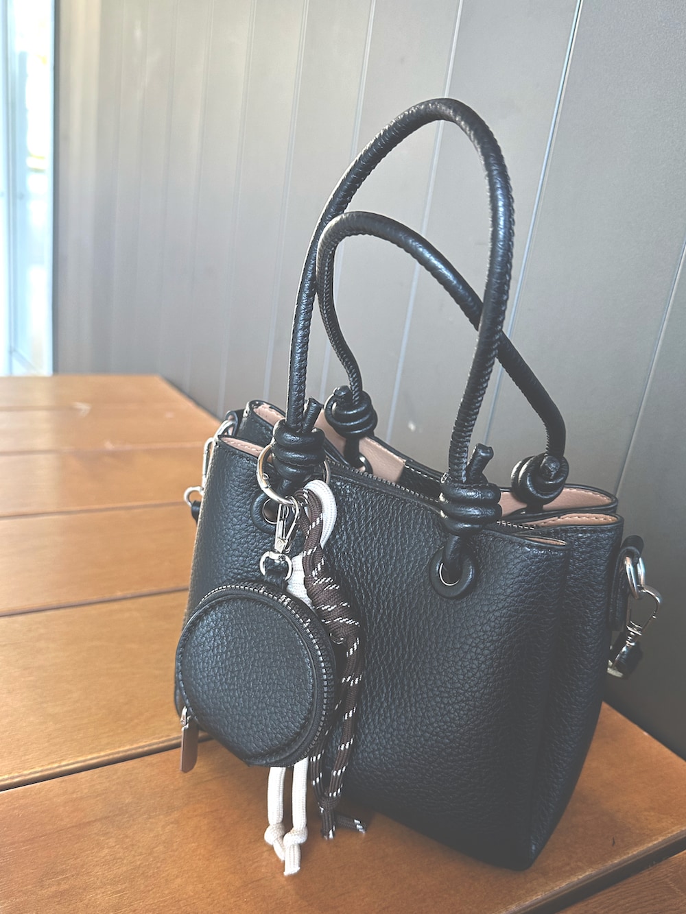 ブラック系のハンドバッグを着用したレディースの冬コーディネートの2枚目の写真