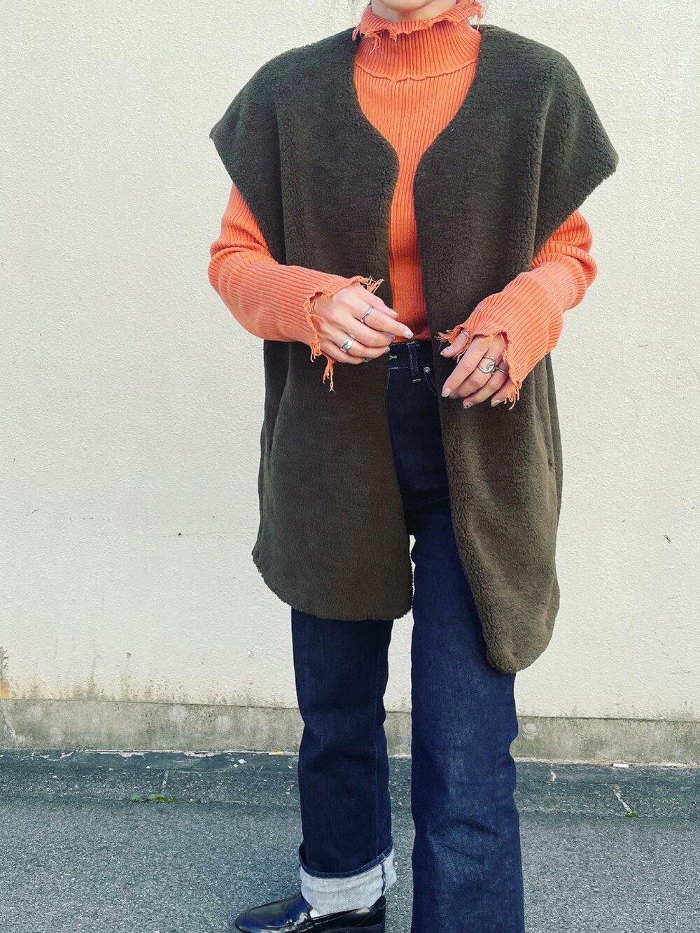 グリーン系のノーカラージャケットを着用したレディースの秋コーディネートの2枚目の写真