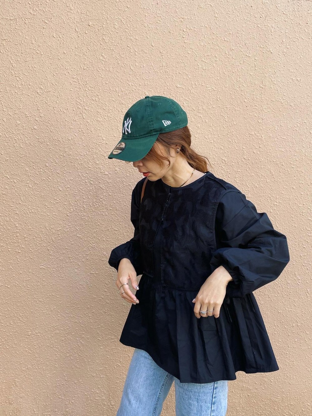 ブラック系のシャツ/ブラウス、グリーン系のキャップを着用したレディースの秋コーディネートの2枚目の写真