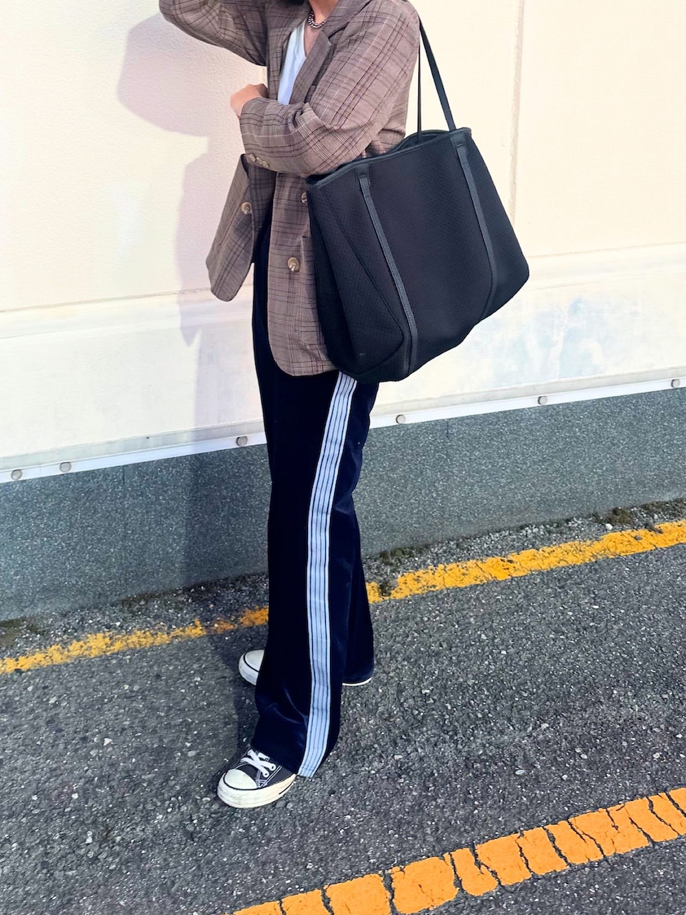 ブラック系のトートバッグを着用したレディースの秋コーディネートの3枚目の写真