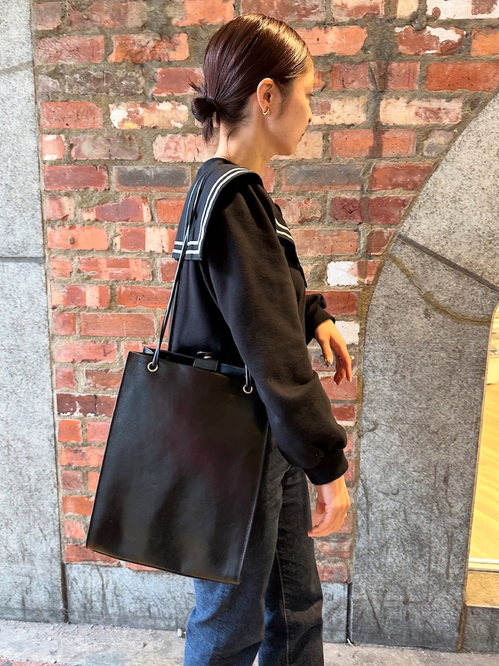 ブラック系のバッグを着用したレディースの秋コーディネートの3枚目の写真