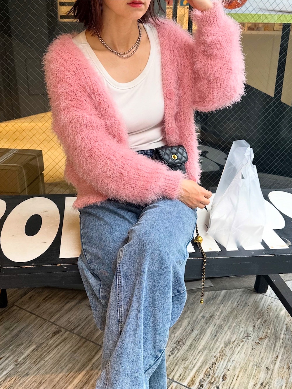 ピンク系のカーディガン/ボレロ、ブラック系のバッグを着用したレディースの秋コーディネートの2枚目の写真