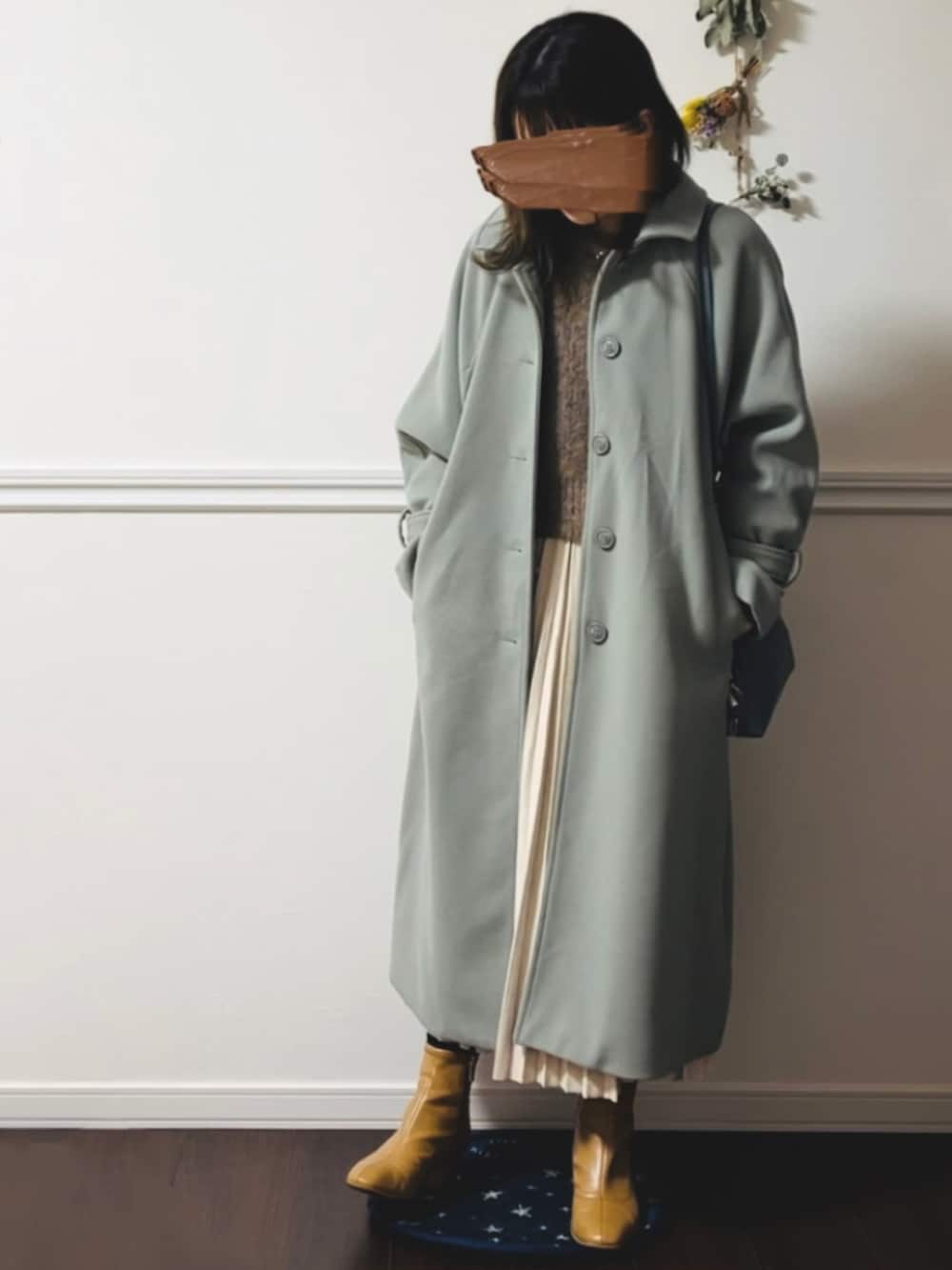 ベージュ系のニット/セーター、ブラック系のブーツを着用したレディースの春コーディネートの2枚目の写真