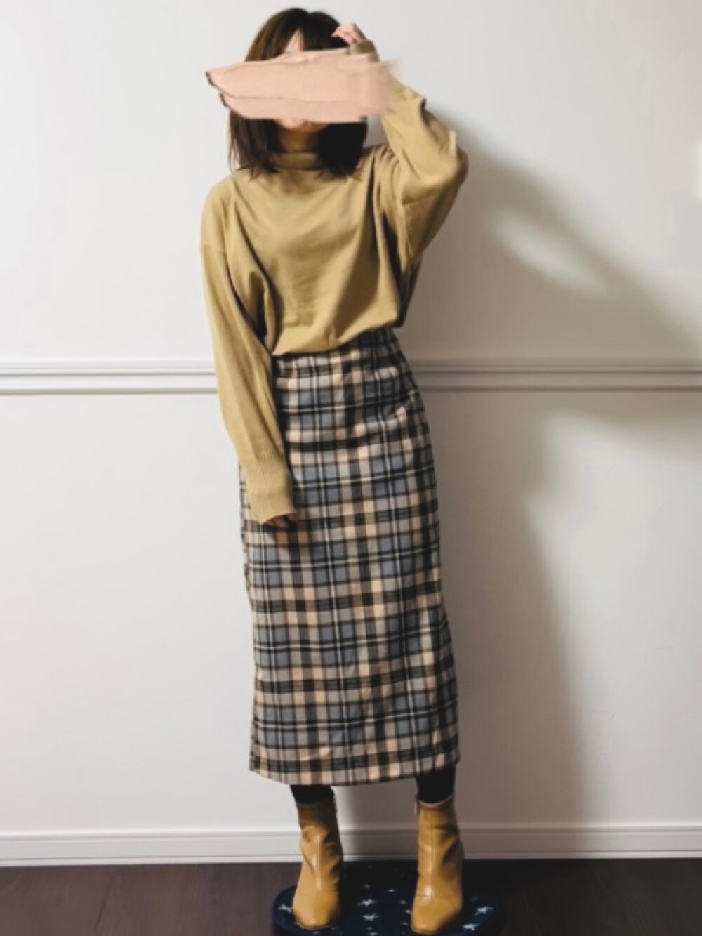 ベージュ系のスカート、ブラック系のブーツを着用したレディースの冬コーディネートの2枚目の写真