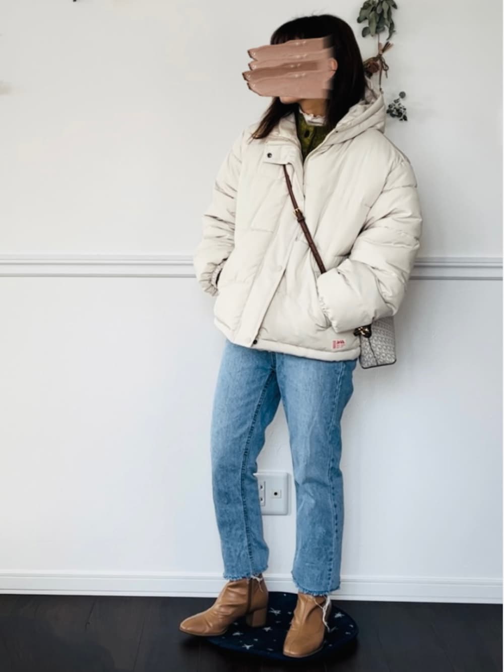 グリーン系のカーディガン/ボレロ、ホワイト系のTシャツ/カットソー、ブラック系のブーツを着用したレディースの冬コーディネートの2枚目の写真