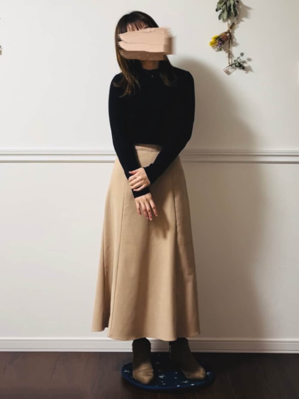 ベージュ系のスカートを着用したレディースの冬コーディネートの2枚目の写真
