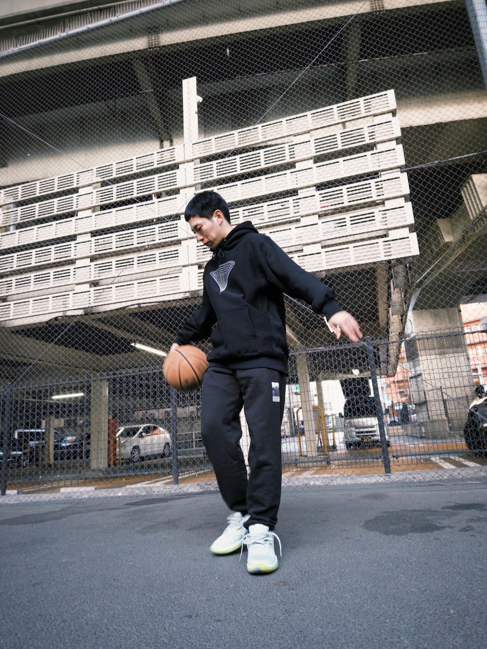 ブラック系のスウェットパンツ、ブラック系のパーカー、グレー系のシューズを着用したメンズの冬コーディネートの2枚目の写真