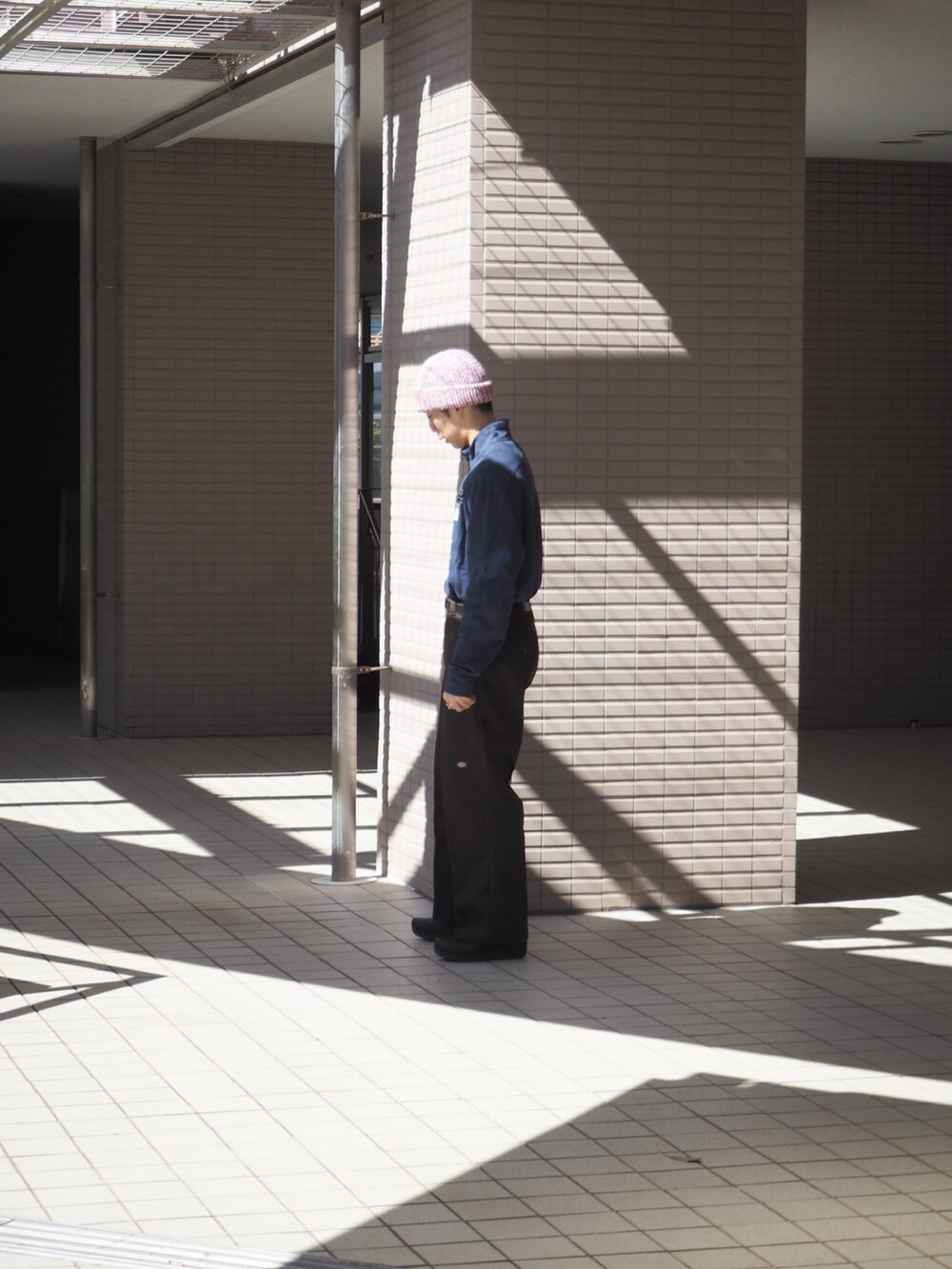 ブラウン系のチノパンツ、ブルー系のトップス、ブラック系のスリッポンを着用したメンズの春コーディネートの3枚目の写真