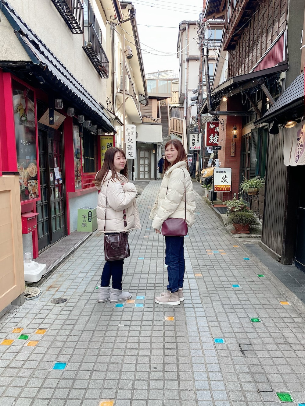 ホワイト系のダウンジャケット/コート、ホワイト系のニット/セーター、ブルー系のデニムパンツを着用したレディースの冬コーディネートの2枚目の写真