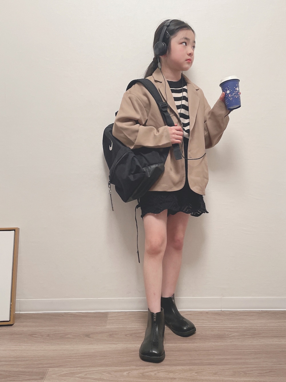ベージュ系のテーラードジャケット、ブラック系のバックパック/リュック、ブラック系のその他パンツを着用したキッズの春コーディネートの2枚目の写真