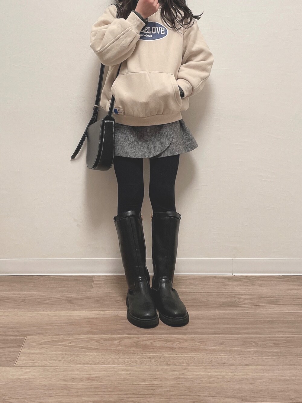 グレー系のスカート、ブラック系のバッグを着用したキッズの冬コーディネートの2枚目の写真