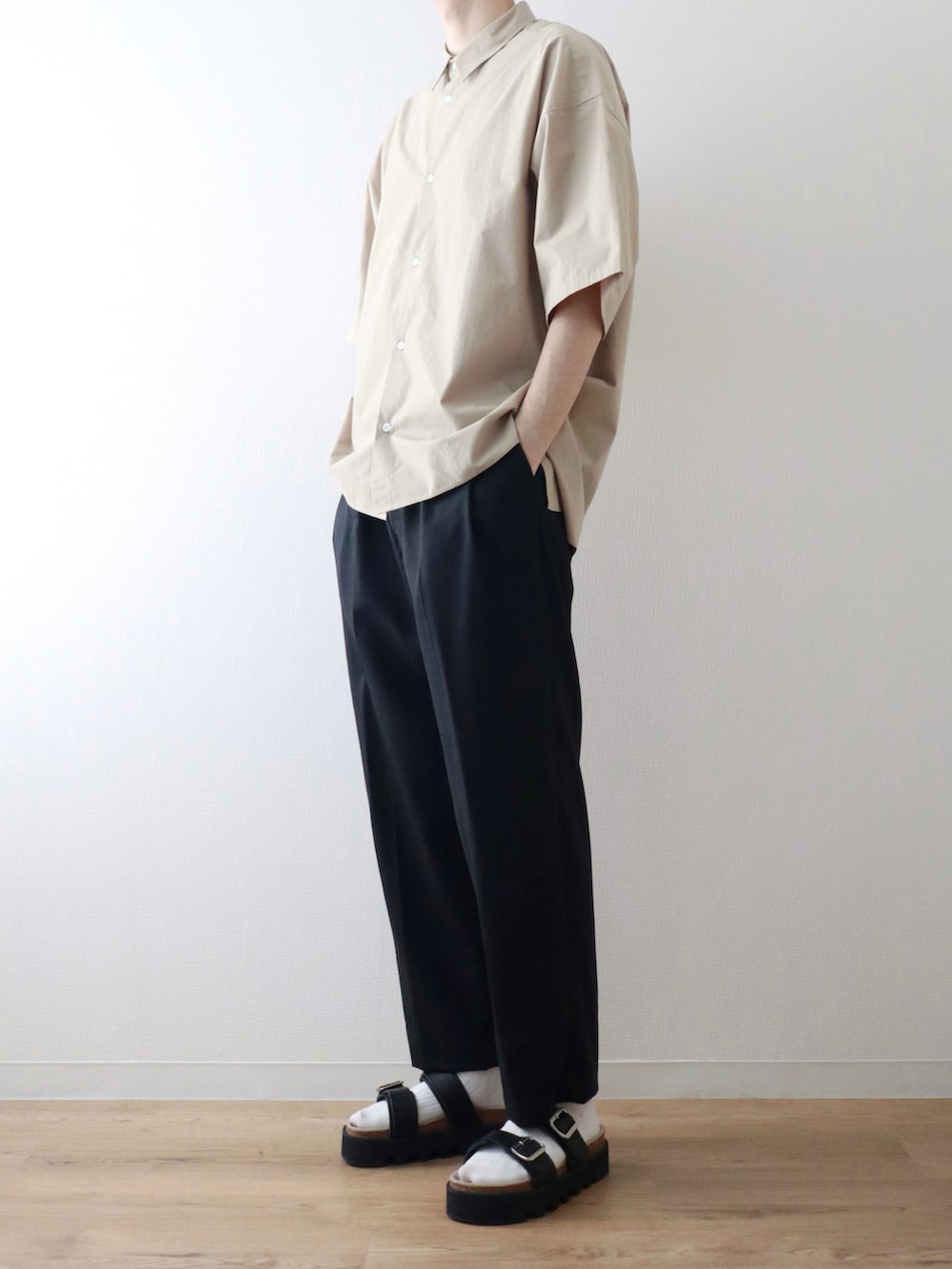 ベージュ系のシャツ/ブラウス、ブラック系のスラックス、ブラック系のサンダルを着用したメンズの夏コーディネートの2枚目の写真