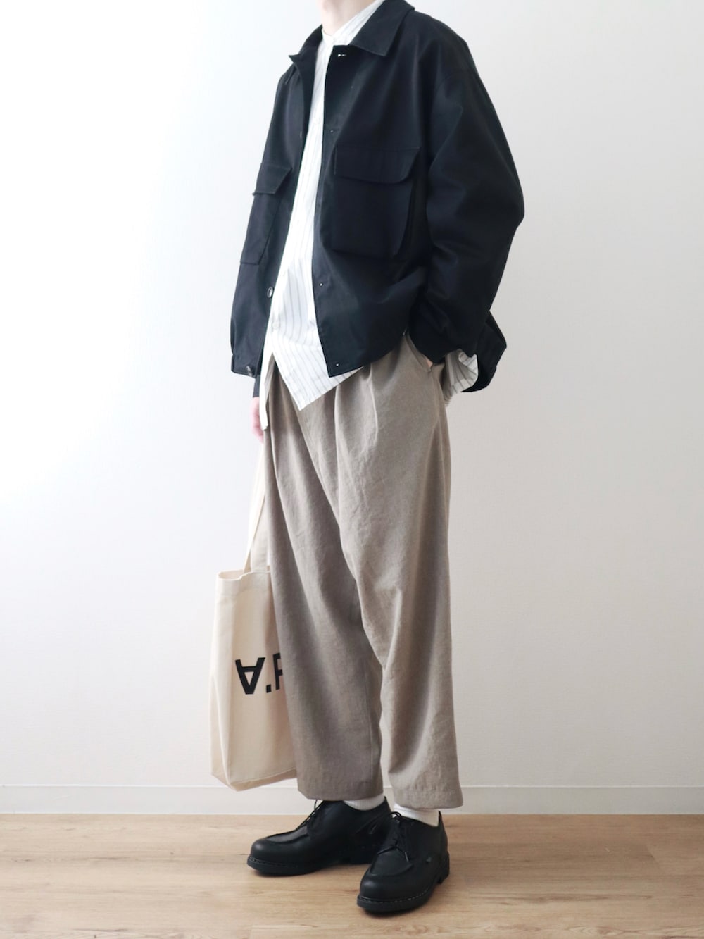 ブラック系のブルゾン、ホワイト系のシャツ/ブラウス、ベージュ系のその他パンツを着用したメンズの春コーディネートの2枚目の写真
