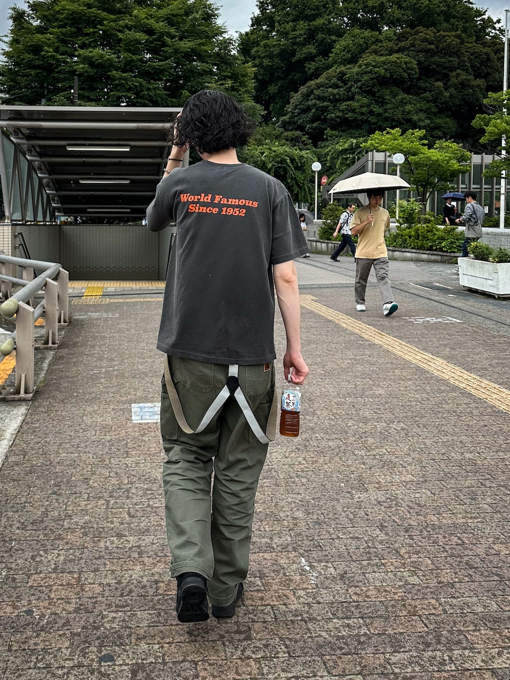 グレー系のTシャツ/カットソー、グリーン系のデニムパンツを着用したメンズの夏コーディネートの2枚目の写真