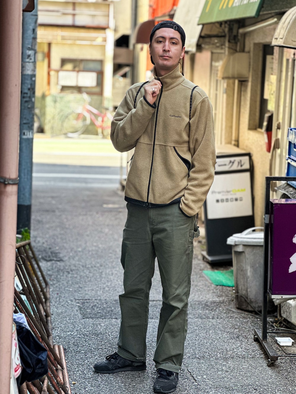 グリーン系のデニムパンツ、ベージュ系のその他アウター、グレー系のスニーカーを着用したメンズの春コーディネートの3枚目の写真