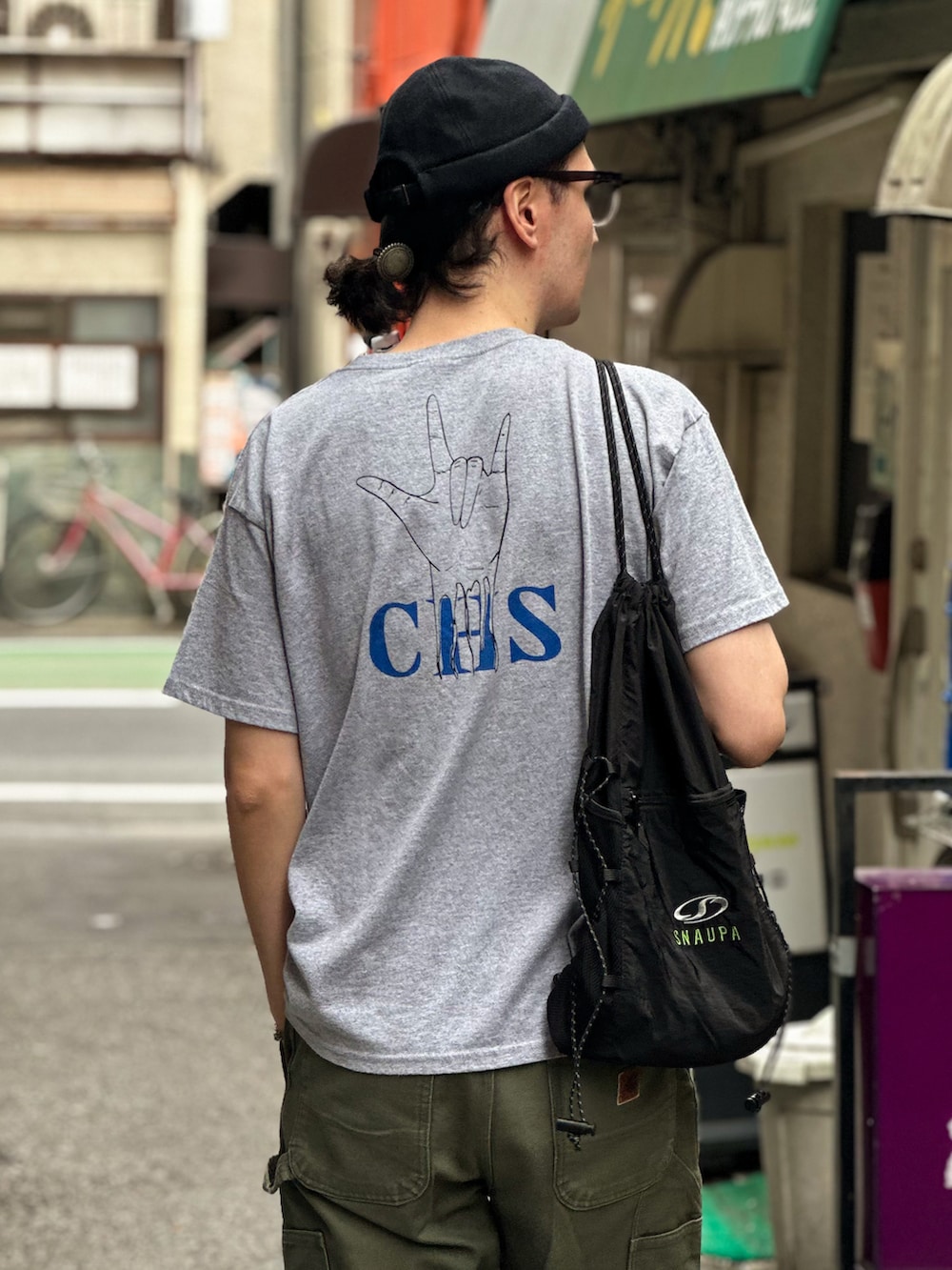 グレー系のTシャツ/カットソー、グリーン系のデニムパンツ、ブラック系のエコバッグ/サブバッグを着用したメンズの秋コーディネートの2枚目の写真