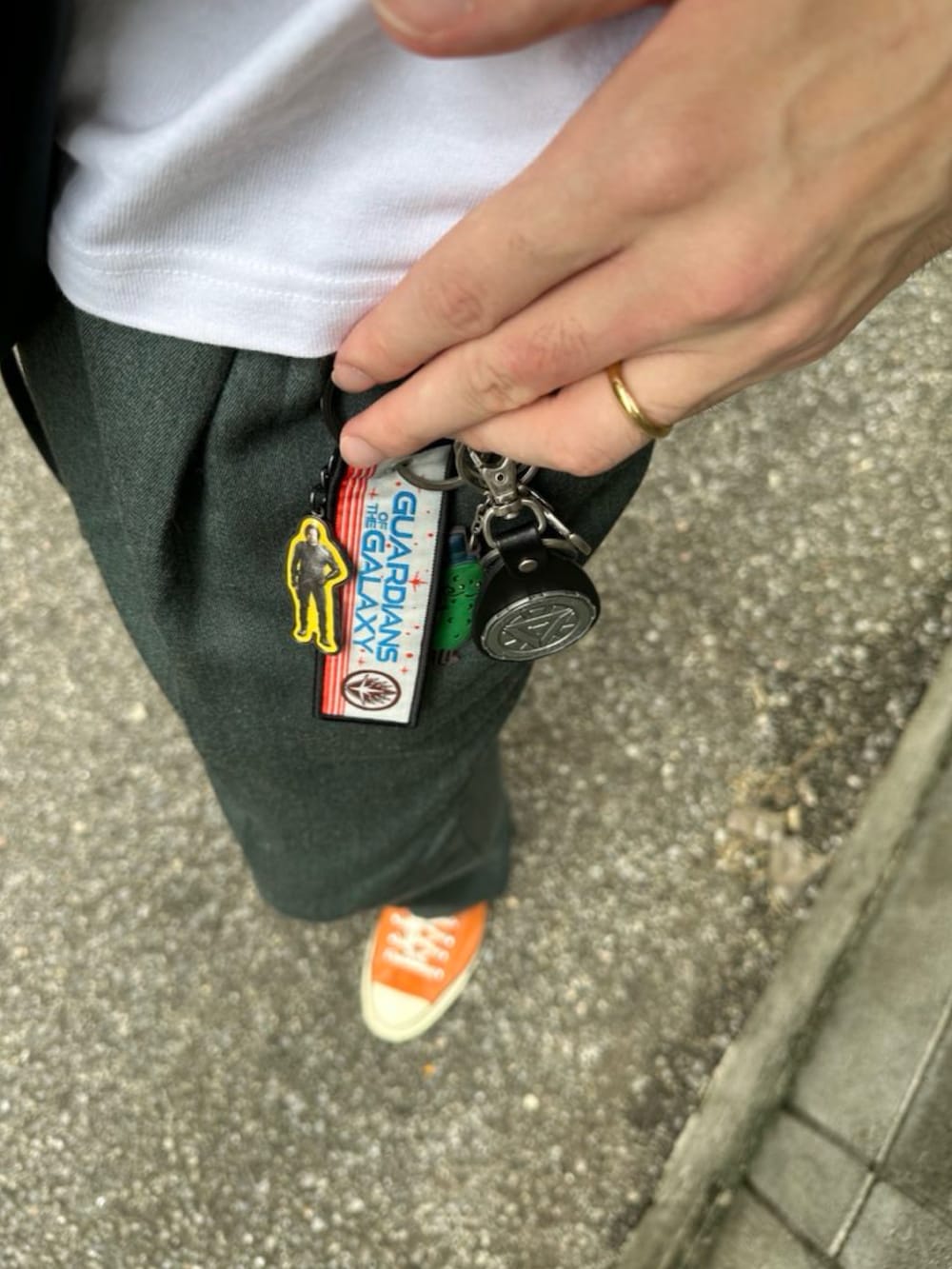 ホワイト系のTシャツ/カットソー、グリーン系のショルダーバッグ、グリーン系のスラックスを着用したメンズの秋コーディネートの3枚目の写真