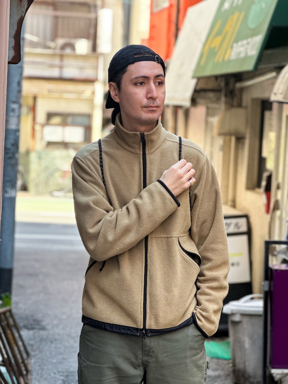 グリーン系のデニムパンツ、ベージュ系のその他アウター、グレー系のスニーカーを着用したメンズの春コーディネートの4枚目の写真