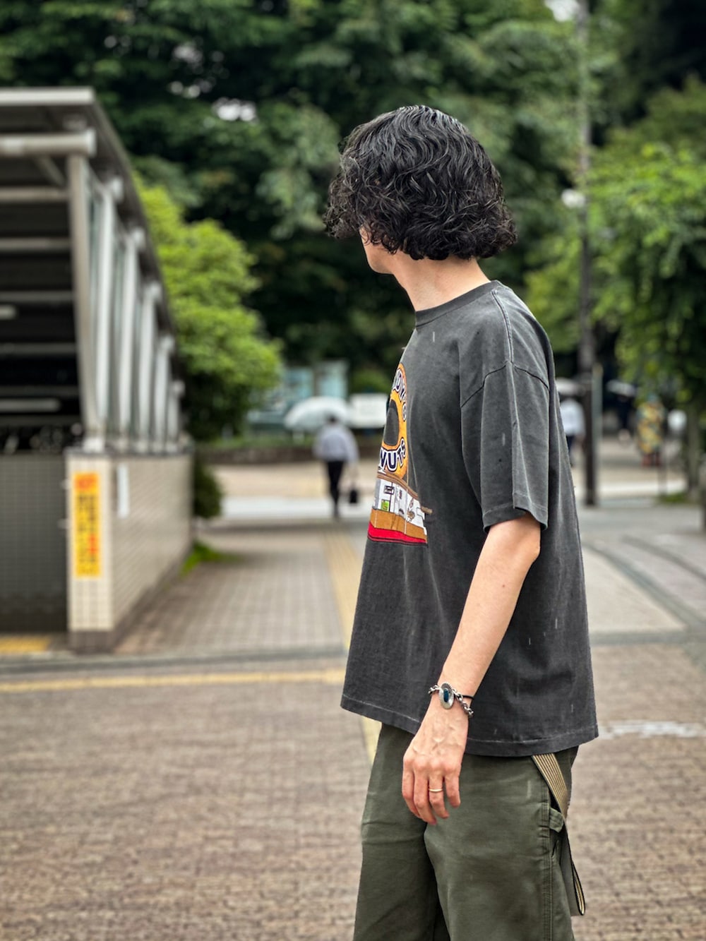 グレー系のTシャツ/カットソー、グリーン系のデニムパンツを着用したメンズの夏コーディネートの3枚目の写真