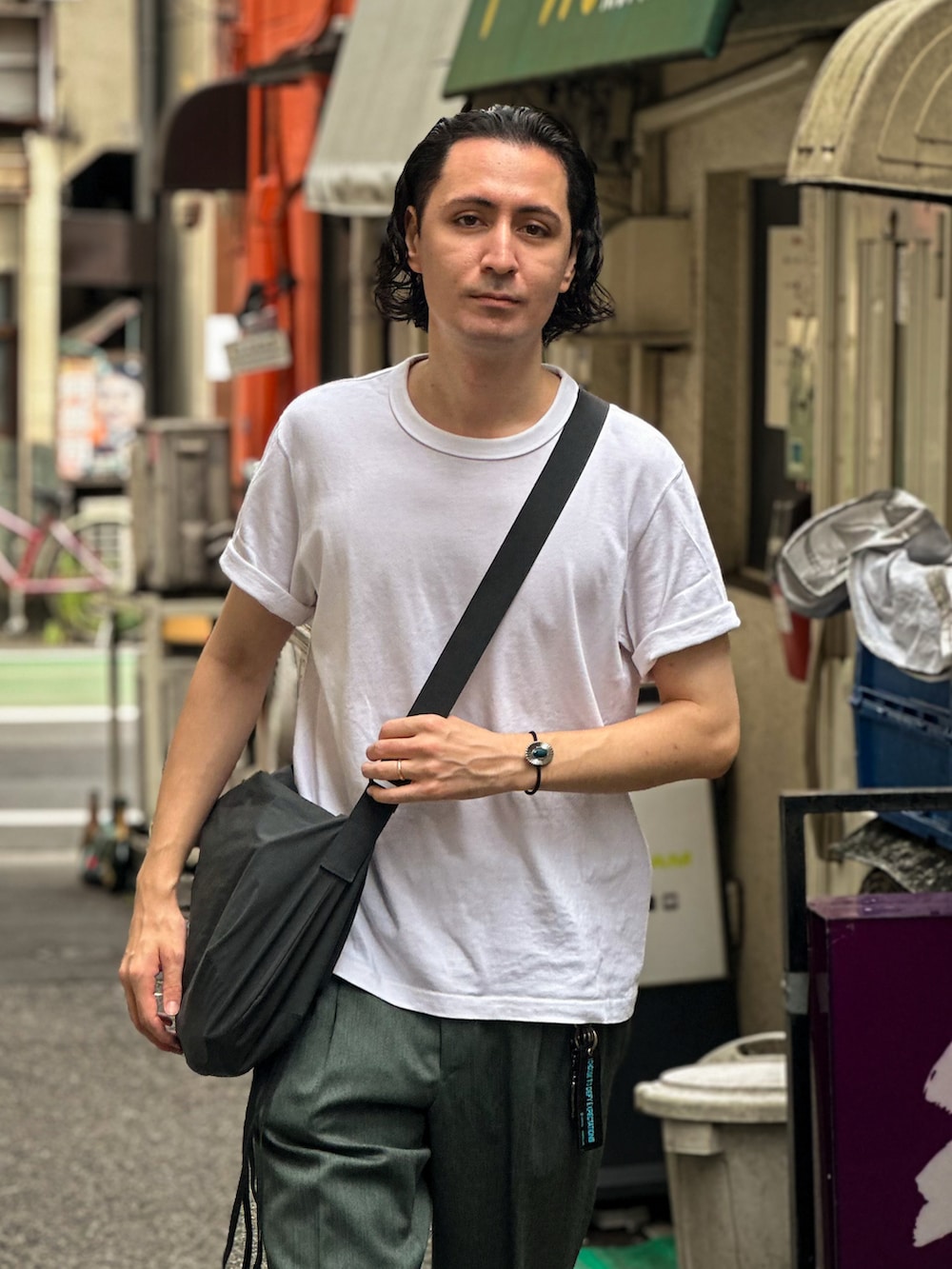 ホワイト系のTシャツ/カットソー、グリーン系のショルダーバッグ、グリーン系のスラックスを着用したメンズの秋コーディネートの2枚目の写真