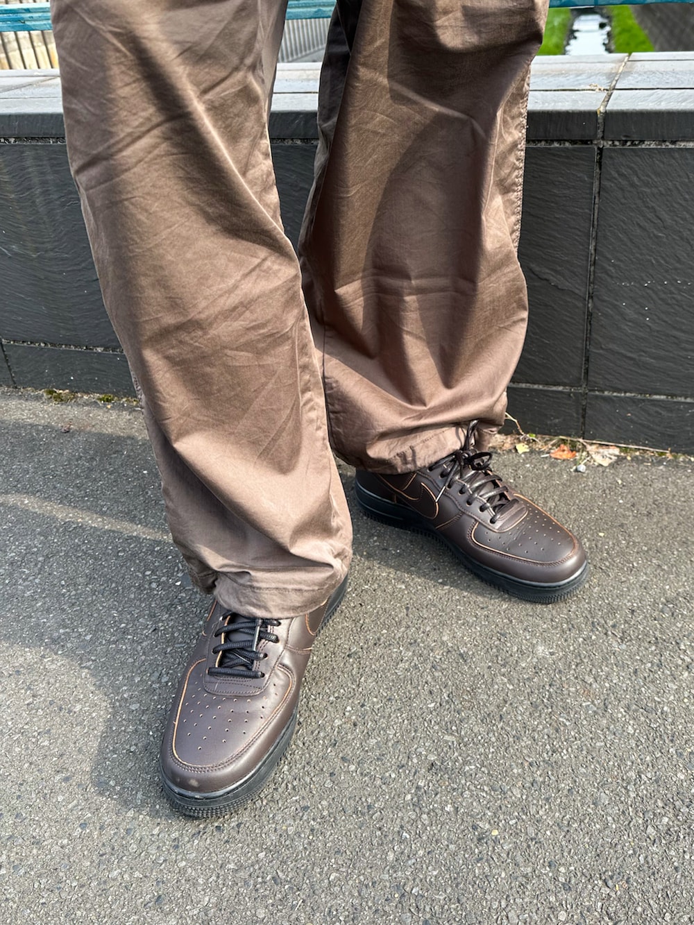 ブラウン系のその他パンツ、ブラウン系のスニーカー、ブラック系のその他アウターを着用したメンズの冬コーディネートの4枚目の写真