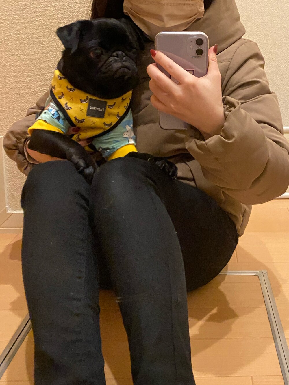 ブラック系のデニムパンツ、ベージュ系のダウンジャケット/コート、イエロー系のリード/ハーネス/首輪を着用したレディースの冬コーディネートの2枚目の写真