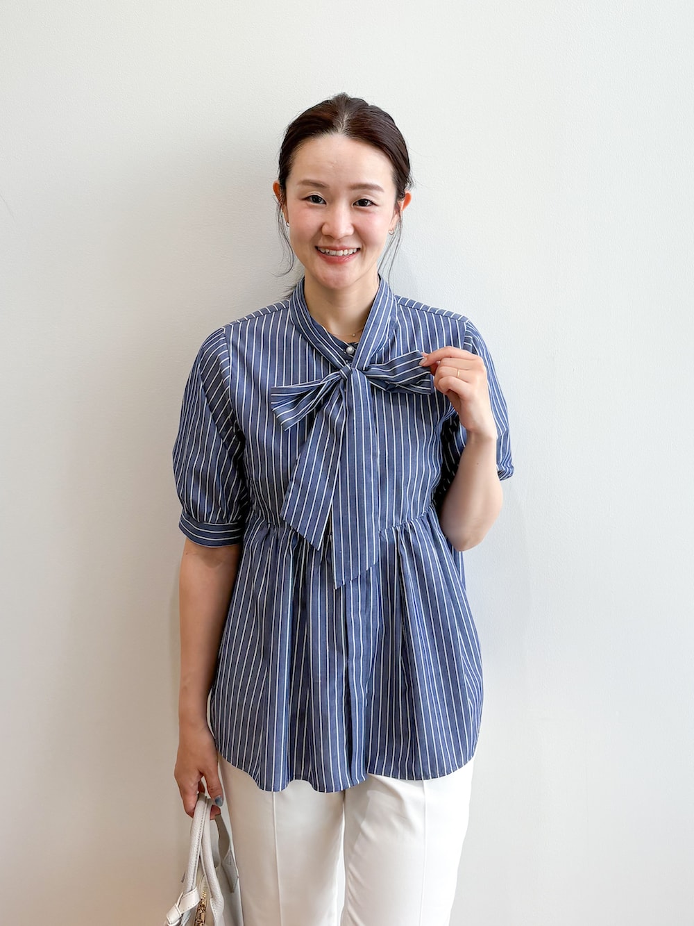 ブルー系のシャツ/ブラウス、ホワイト系のその他パンツ、ベージュ系のボストンバッグを着用したレディースの夏コーディネートの6枚目の写真