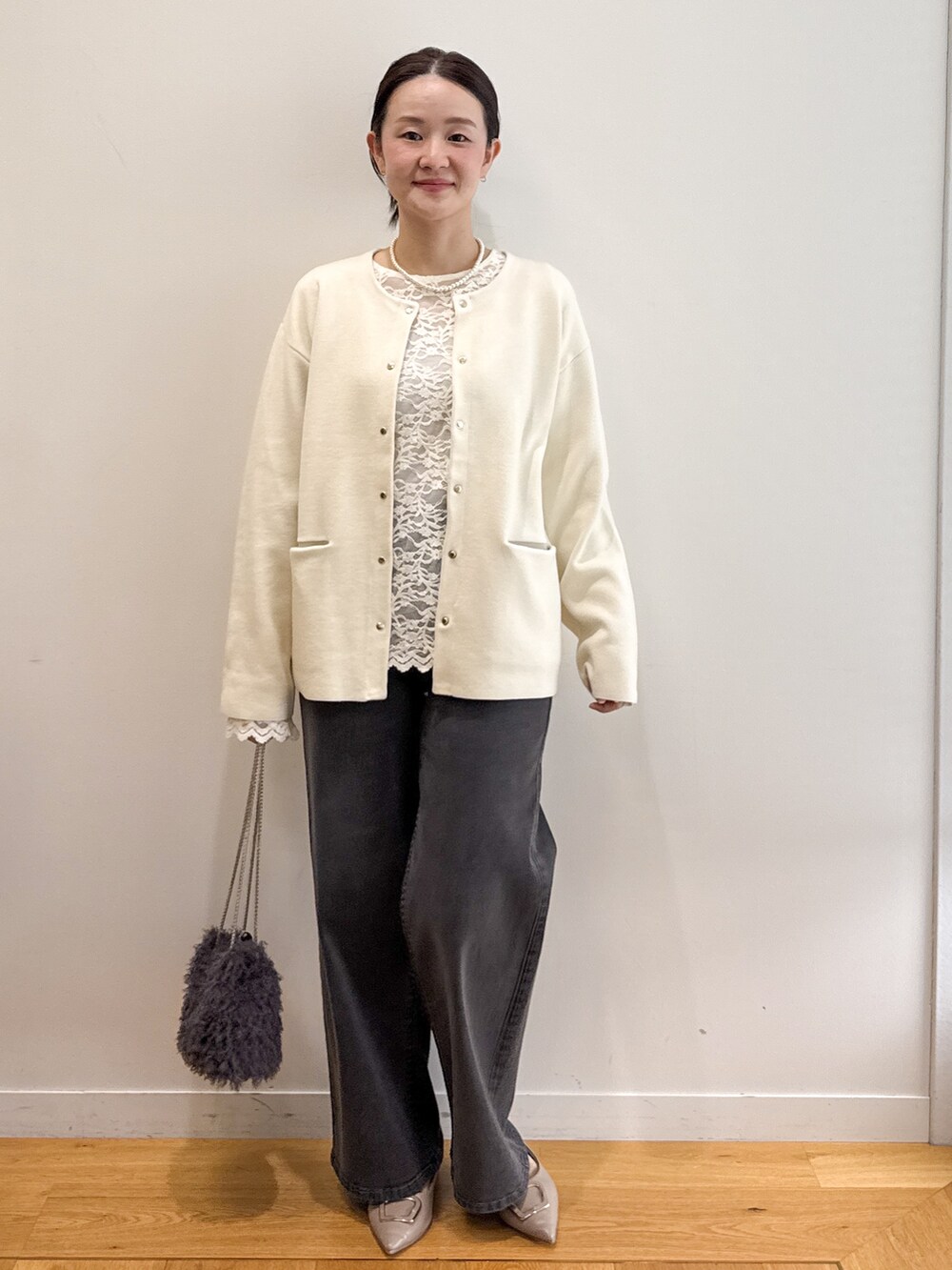 ホワイト系のカーディガン/ボレロ、ホワイト系のTシャツ/カットソー、ブラック系のデニムパンツを着用したレディースの秋コーディネートの3枚目の写真