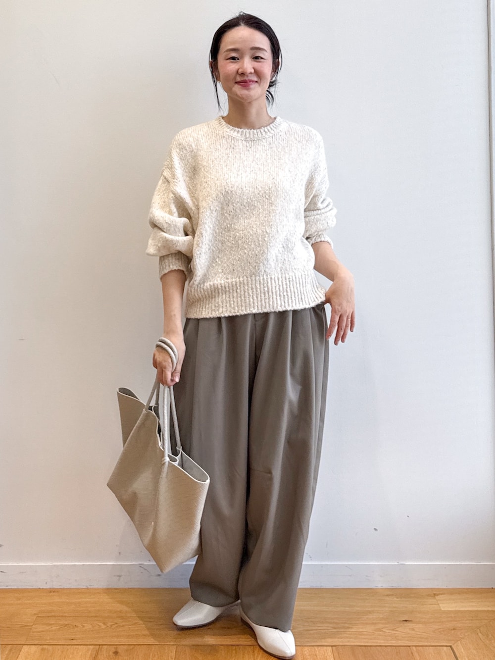 ホワイト系のニット/セーター、グリーン系のその他パンツ、ベージュ系のトートバッグを着用したレディースの夏コーディネートの4枚目の写真