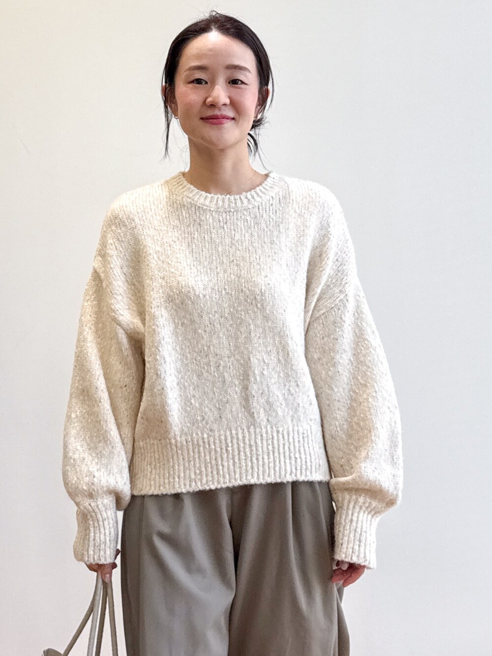 ホワイト系のニット/セーター、グリーン系のその他パンツ、ベージュ系のトートバッグを着用したレディースの夏コーディネートの8枚目の写真