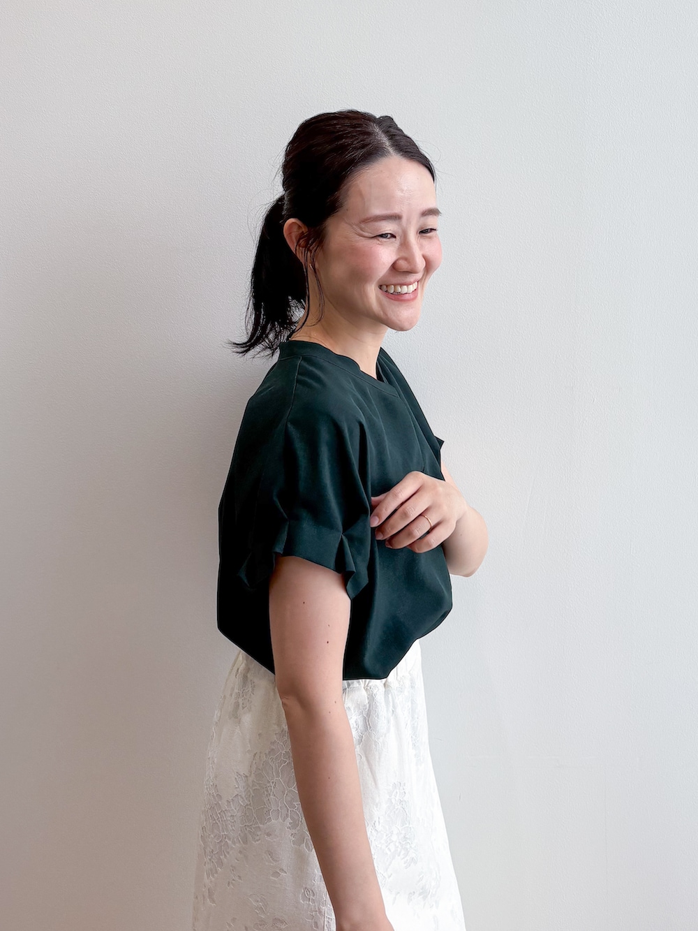 グリーン系のシャツ/ブラウス、ホワイト系のスカート、グレー系のパンプスを着用したレディースの夏コーディネートの6枚目の写真