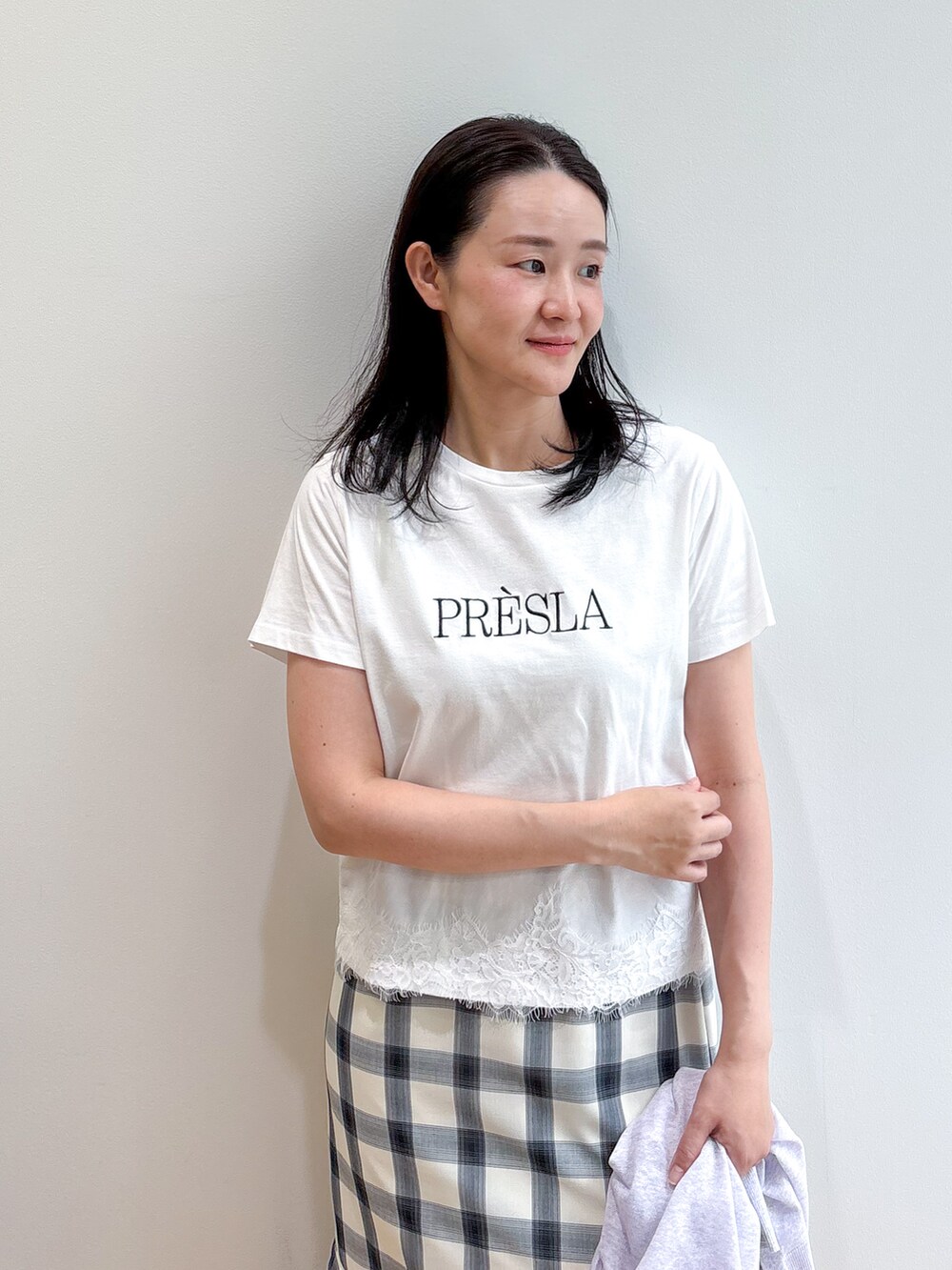 ホワイト系のTシャツ/カットソー、ホワイト系のスカート、グレー系のパンプスを着用したレディースの夏コーディネートの5枚目の写真